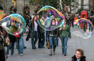 Londra, Regno Unito, 2005. Guardare la folla attraverso le bolle create da un animatore di strada foto