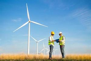 team di ingegneri che lavora nella fattoria di turbine eoliche. energia rinnovabile con generatore eolico dal concetto di energia alternativa. foto