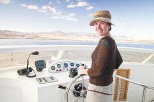 giovane donna attraente che dirige una barca foto
