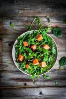 insalata di spinaci e rucola fresca con zucca su backgroun rustico foto
