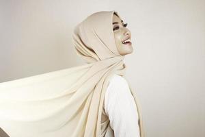 donna musulmana che indossa abiti tradizionali e hijab isolati su sfondo bianco. l'hijab è fatto volare in modo creativo. idul fitri e concetto di moda hijab. foto