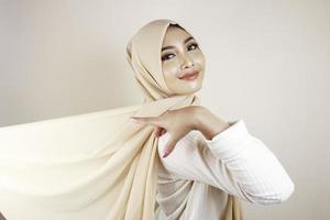 donna musulmana che indossa abiti tradizionali e hijab isolati su sfondo bianco. l'hijab è fatto volare in modo creativo. idul fitri e concetto di moda hijab. foto