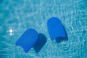 tavola di gommapiuma blu per insegnare a nuotare in piscina foto