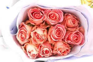 rosa arancione bella rosa avvolta in carta in vendita al mercato dei fiori, regalo presente il giorno di San Valentino. foto