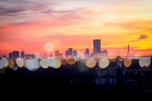 cielo mattutino arancione alba sopra la vista del grattacielo della città con la luce del bokeh, il paesaggio urbano dell'orizzonte dell'orizzonte e gli edifici di architettura urbana all'alba foto