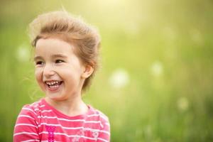 ritratto di una ragazza carina in campo con un fiore selvatico. infanzia, vacanze in campagna, libertà e spensieratezza. estate. giornata internazionale dei bambini. repellente per zanzare, nucleo cottage. copia spazio foto