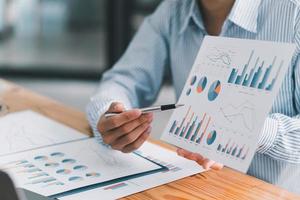 gli uomini d'affari finanziari analizzano il grafico delle prestazioni dell'azienda per creare profitti e crescita, rapporti di ricerche di mercato e statistiche sul reddito, concetto finanziario e contabile. foto