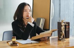 avvocati donne aprono e leggono con un libro di legge sul suo posto di lavoro. foto