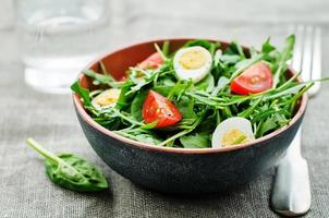 insalata con rucola, spinaci, pomodori e uova. foto