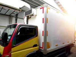 camion logistico auto con box frigorifero in zona industriale. foto