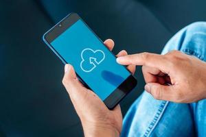 uomo d'affari che utilizza smartphone e collega il servizio di cloud computing con la connessione di rete del cliente icona. archiviazione online del dispositivo cloud. concetto di rete Internet con tecnologia cloud. foto