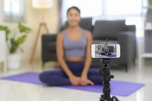 allenatore di yoga professionale che insegna lezioni di formazione online agli studenti durante lo streaming live sui social media, concetto di assistenza sanitaria foto