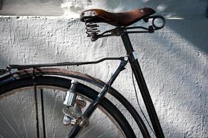 dettaglio di un seggiolino da bicicletta vintage, ruota, dinamo e lucchetto foto