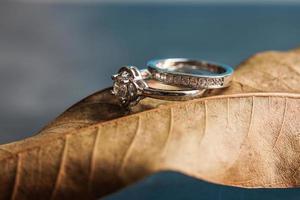 primo piano di un anello di fidanzamento con diamante posto su una foglia. concetto di amore e matrimonio. foto