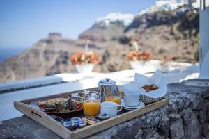 colazione a santorini in hotel. atmosfera di lusso con frittata fresca e frutta con succo di frutta con vista sul mare. lussuoso sfondo per le vacanze estive in viaggio. vibrazioni di relax felici, tavolo del primo piano del mattino delle coppie foto