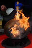 uno chef prepara cibo cinese a un festival del cibo di strada. foto