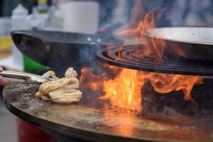 cucinare gamberetti, spiedini di gamberi alla griglia al festival del cibo di strada - primo piano foto