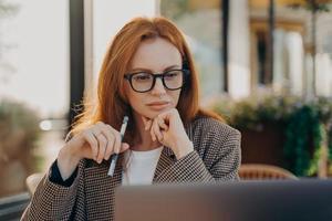 donna d'affari esperta in abiti eleganti guarda video sulla creazione di una startup foto