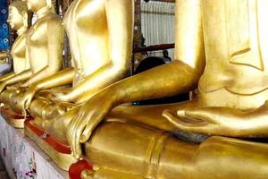 la fila della statua del buddha di colore dorato è la postura seduta, bangkok, tailandia. foto