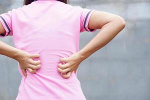 parte posteriore della donna bianca mal di schiena e concetto di dolore, donna asiatica pruriginosa nella parte posteriore foto