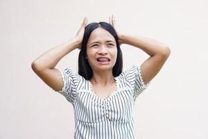 le donne asiatiche soffrono di stress lavorativo. metti le mani sulla testa foto