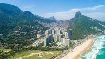 veduta aerea della favela da rocinha, la più grande baraccopoli del brasile sulla montagna di rio de janeiro e lo skyline della città alle spalle foto