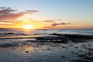 tramonto panoramico sul mare. il sole tramonta sull'acqua. il cielo nuvoloso è dipinto con colori vivaci. spiaggia al tramonto in una sera d'estate. brasile. foto