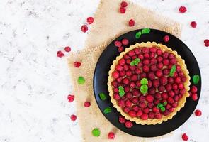 deliziosa torta con crema pasticcera e lampone su fondo di legno foto