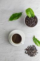 tazza di caffè con chicchi di caffè su sfondo bianco foto