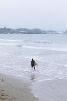 surfista su una spiaggia nebbiosa foto