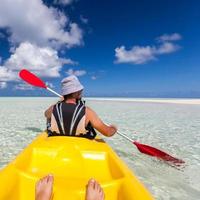 giovane uomo caucasico kayak in mare alle Maldive