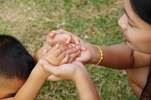 la mano della madre che tiene la mano di una bambina su sfondo bokeh. concetto di amore e famiglia. foto