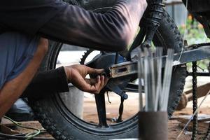 un uomo lavora come meccanico in un'officina di riparazione di motociclette locale foto