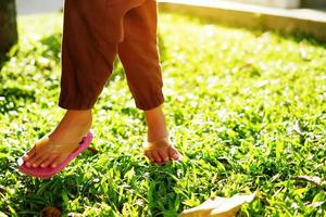 parte del piede di una bambina nel parco sotto il caldo sole pomeridiano foto