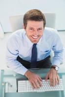 uomo d'affari sorridente con il suo computer foto