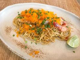Spaghetti saltati in padella con frutti di mare e uovo di gamberi foto