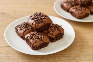 Brownies al cioccolato fondente ricoperti da gocce di cioccolato foto