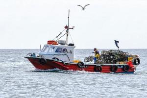 craster, Northumberland, Regno Unito, 2010. Impostazione delle nasse da una barca da pesca vicino a craster foto