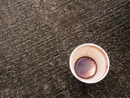 macchia di caffè sul fondo di un bicchiere di carta foto