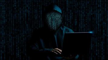 faccia hacker realizzata con codice binario hacker di computer anonimo, attacco informatico, hacker che utilizza il laptop, hacking di Internet, concetto di sicurezza dei dati degli hacker. foto