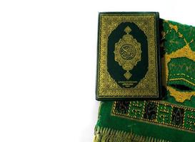 foto del Corano e tappeti di preghiera pronti per il ramadan. l'arabo sulla copertina è tradotto come corano