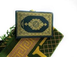 foto del Corano e tappeti di preghiera pronti per il ramadan. l'arabo sulla copertina è tradotto come corano