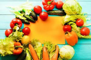 verdure diverse sul tavolo della cucina con elenco di ricette e spazio per la copia. vista dall'alto foto