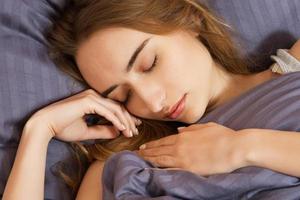 bella ragazza dorme in camera da letto. Sleepinf donna a letto da vicino. giovane bella donna che dorme. ritratto della giovane e bella donna che dorme nel letto scuro. foto