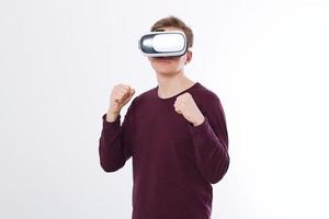 giovane e indossa occhiali di realtà virtuale isolati su sfondo bianco. auricolare con tecnologia occhiali vr e gioco di boxe. copia spazio e simula foto