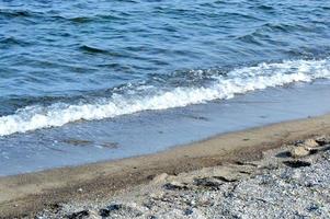 bella foto romantica, mare sulla spiaggia. paesaggio marino rilassante. onde con schiuma sul mare. giornata di sole estivo. spirito di vacanza. Bel paesaggio. sfondo della natura.