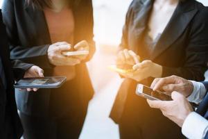 gruppo di giovani uomini d'affari in piedi e utilizzando smartphone insieme concetti di comunicazione. foto