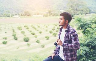 uomo barbuto bello hipster con una tazza di caffè mattutino che cammina nel parco. foto