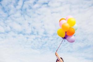 bella ragazza che salta con palloncini sulla spiaggia foto