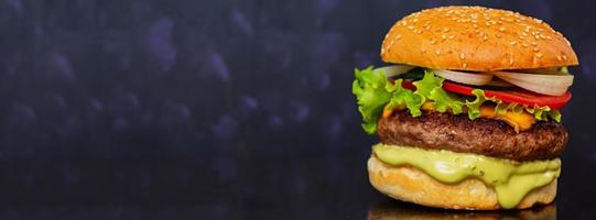 delizioso hamburger fatto a mano su sfondo scuro. striscione. foto
